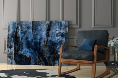 Blue abstract glass wall art with black and white distressed texture displayed in modern living room interior with wooden chair.