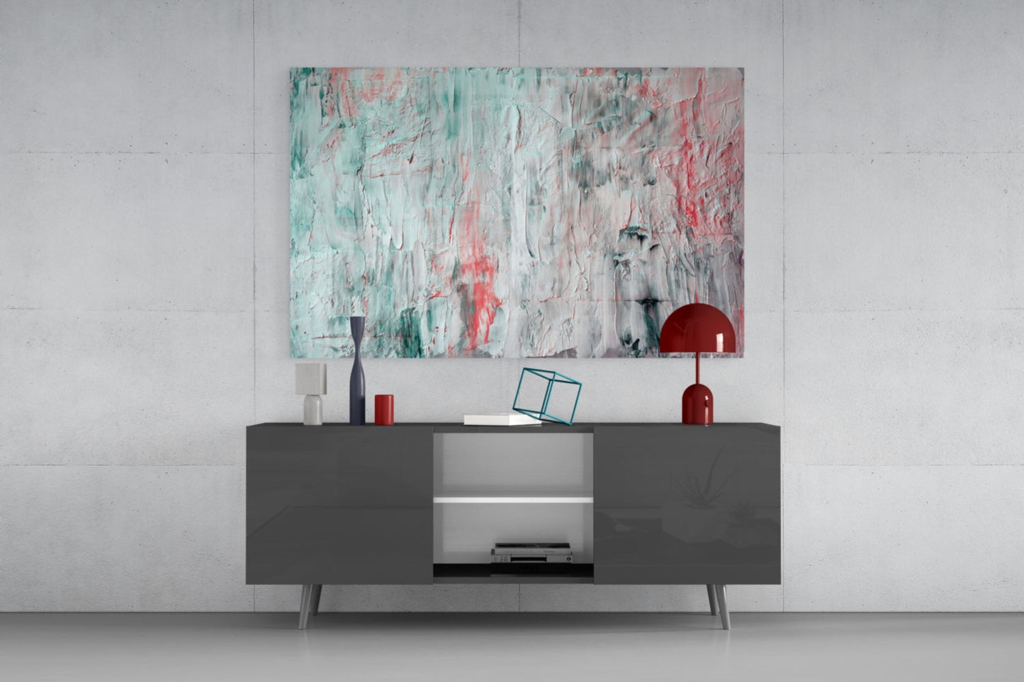 Abstract glass wall art with turquoise, coral, and white paint strokes hung above dark gray media console in modern interior.
