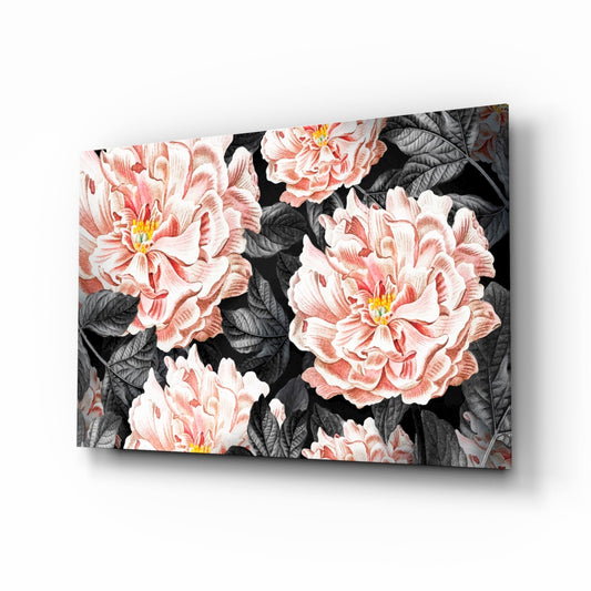 Angled view of coral peony glass wall art on black background, showing pink layered flowers with yellow centers and dark foliage.