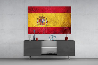 Spanish flag glass wall art with red and yellow horizontal stripes and coat of arms displayed above modern gray media console.