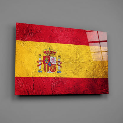 Spanish flag glass wall art displayed at an angle, showing red and yellow horizontal stripes with central coat of arms detail.