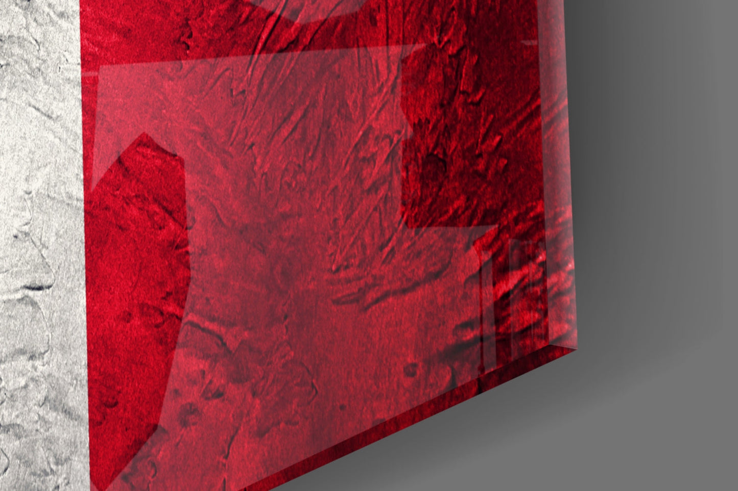 Red glass Italian flag panel tilted at angle against white concrete wall, showing translucent layered red sections and texture.
