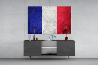 French flag glass wall art displaying blue, white, and red vertical stripes hung above a gray media console in a modern interior setting.