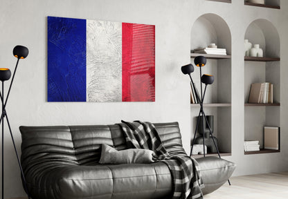 French flag glass wall art with blue, white, and red vertical stripes displayed above black leather sofa in modern living room.