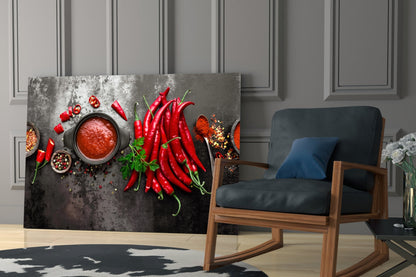 Red peppers glass wall art displayed in a modern living room with wooden chair and grey paneled walls.