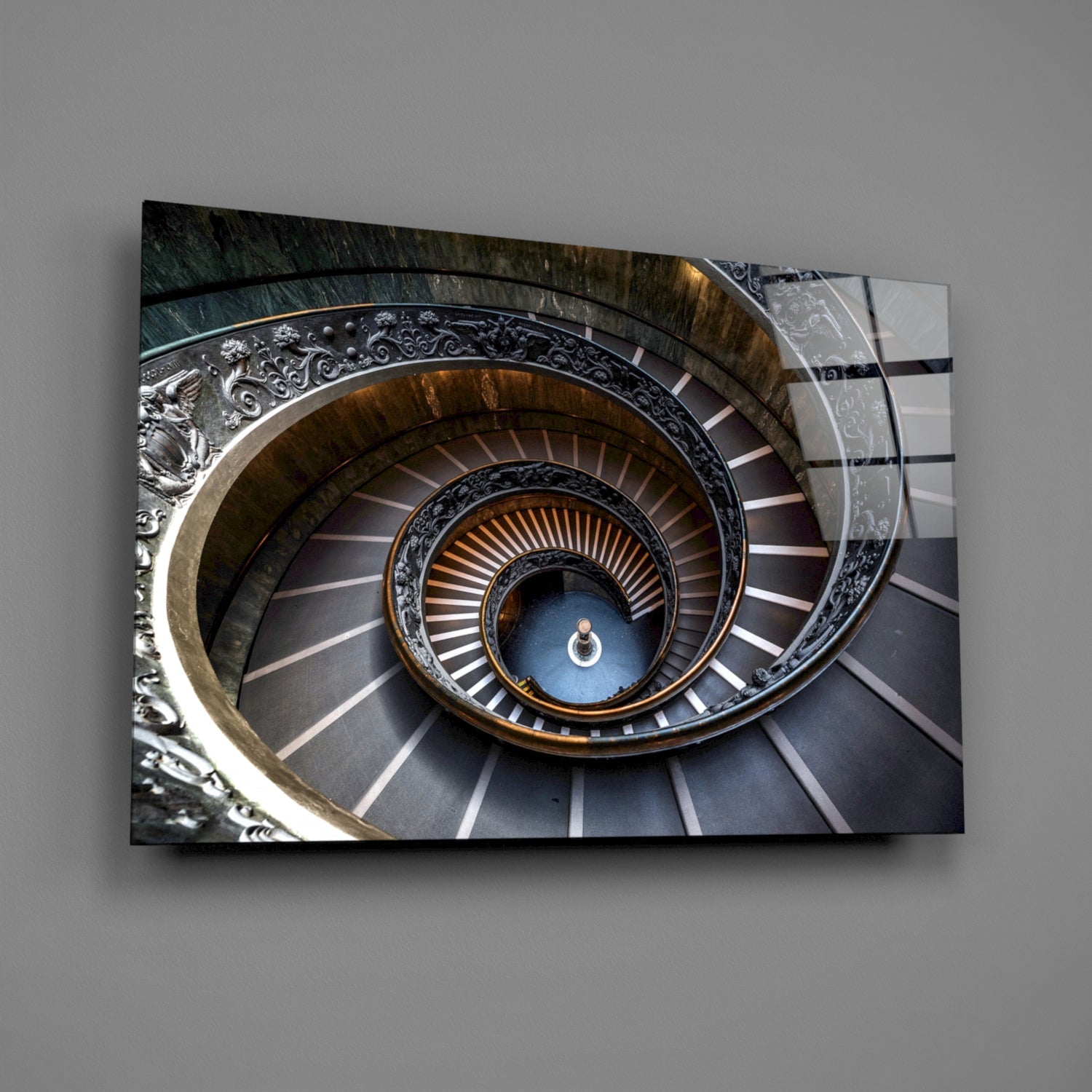 Ornate spiral staircase with decorative metal railings and figure descending into blue-lit center, displayed as wall art.