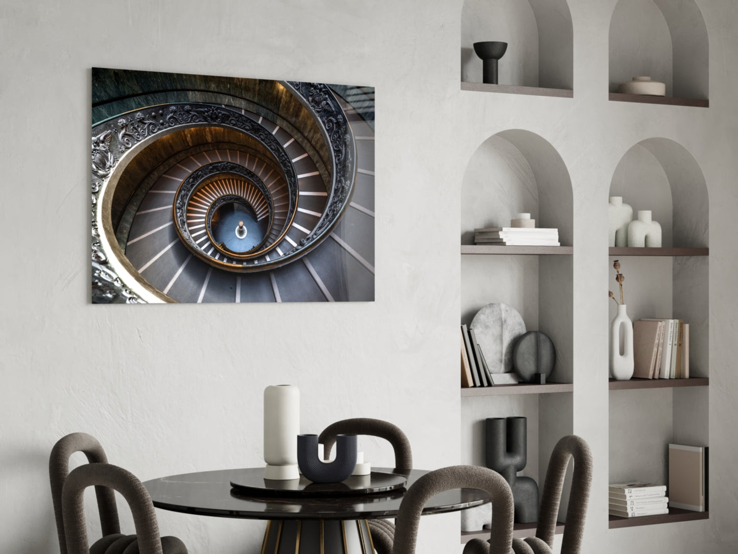 Ornate spiral staircase with decorative railings and blue sky visible at center, displayed above dining table in modern interior.