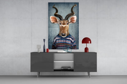 Deer head glass wall art displayed above a dark gray media console, showing an antelope wearing a patterned sweater against a blue background.