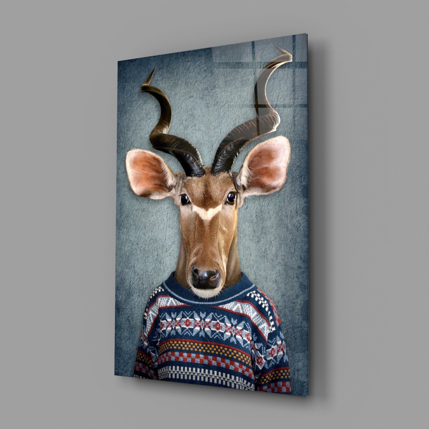 Antelope wearing patterned sweater displayed on angled blue-gray glass panel against white wall.