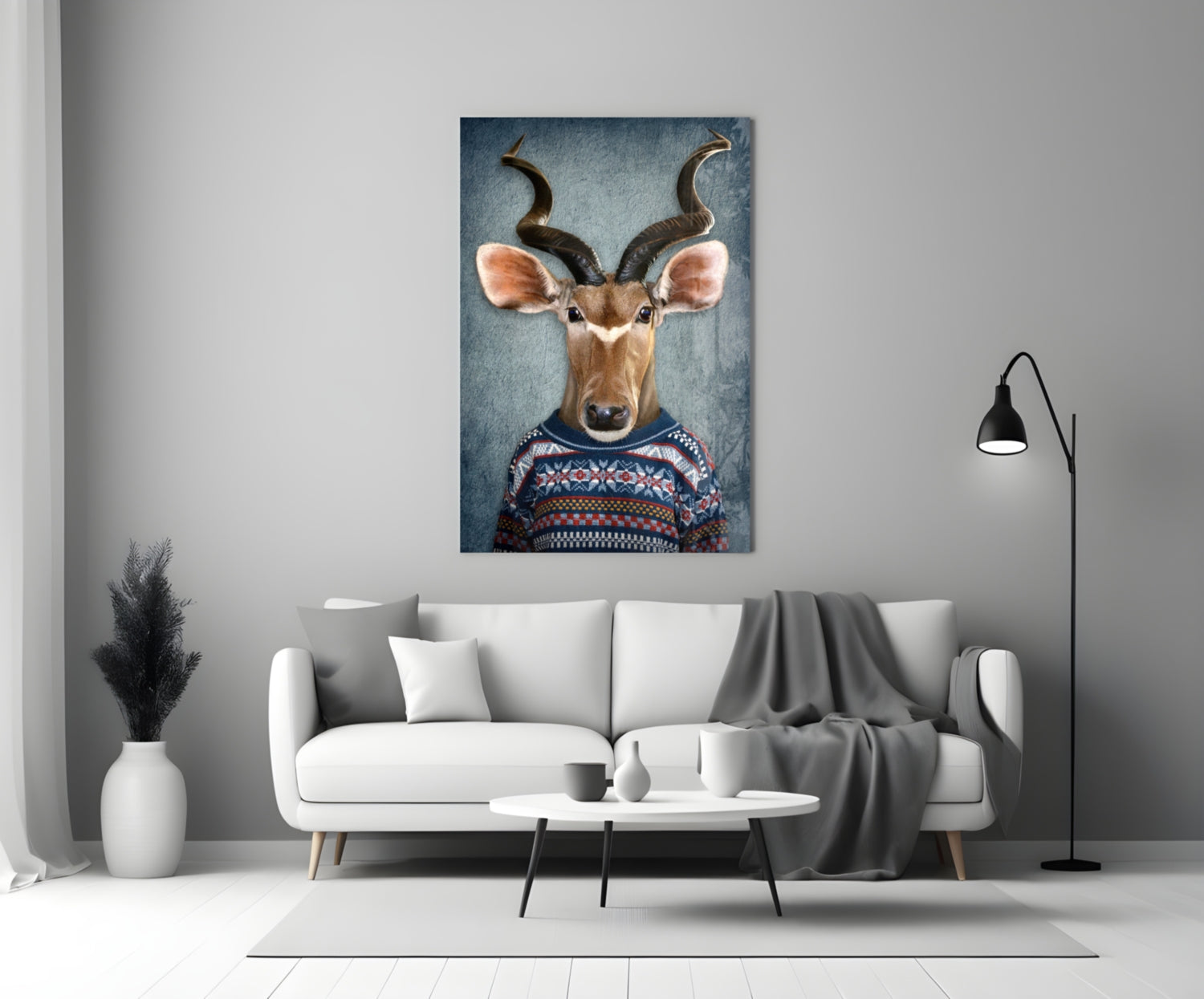 Deer Head Glass Wall Art displayed above white sofa in modern living room setting, showing antelope wearing patterned sweater against blue background.