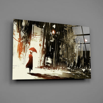Glass wall art panel displaying an illustrated rainy street scene with a figure holding a red umbrella against weathered urban buildings.
