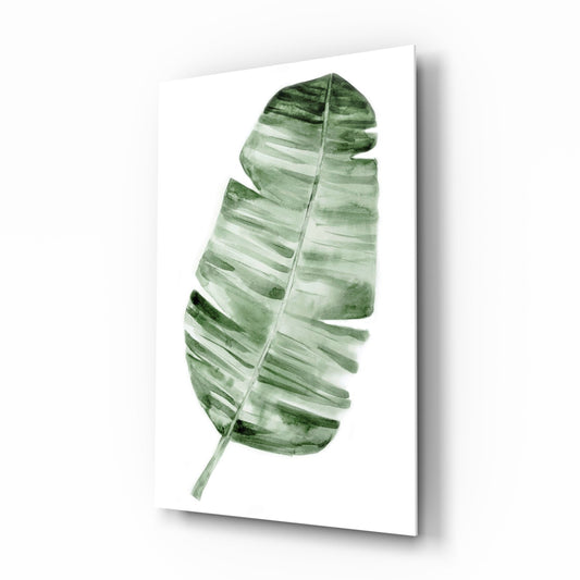 Single green watercolor banana leaf on white background displayed as tilted glass wall art panel.