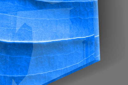 Close-up angled view of blue glass wall art showing translucent layered leaf vein texture and surface details.