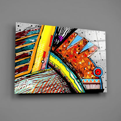 Colorful abstract glass wall art displayed at an angle against gray background, featuring vibrant geometric patterns in yellow, red, orange, blue, and black with decorative designs.