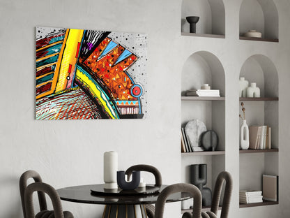 Colorful abstract chameleon glass art hanging above a round black dining table with gray upholstered chairs and white shelving.