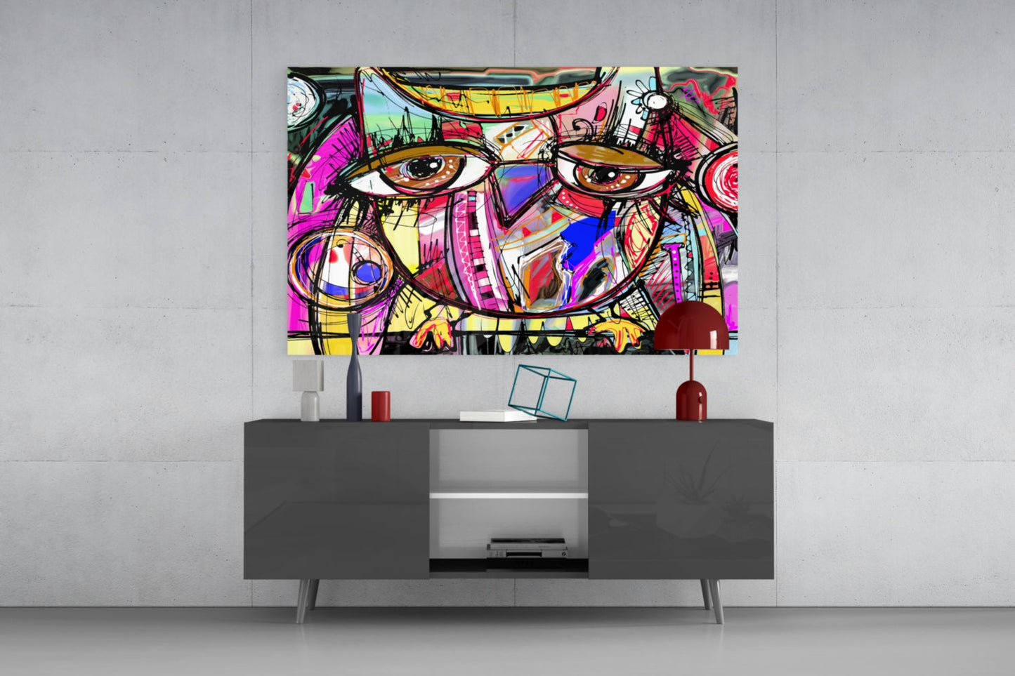 Colorful abstract owl glass wall art hanging above gray TV console, displaying vibrant pink, yellow, and blue geometric patterns with bold black outlines.