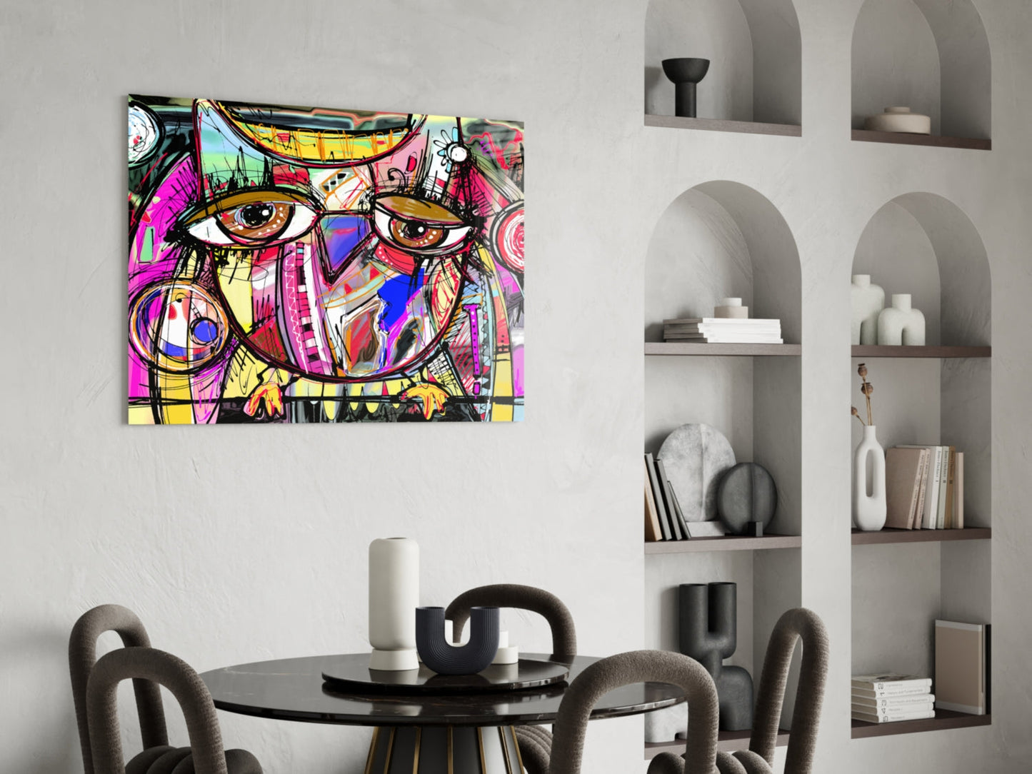Colorful abstract owl glass wall art with magenta, yellow, and blue patterns displayed above a dining table in a modern interior.