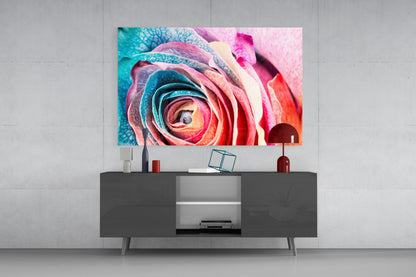 Colorful rose glass wall art displaying pink, red, and turquoise petals mounted above a dark gray media console in a modern interior setting.