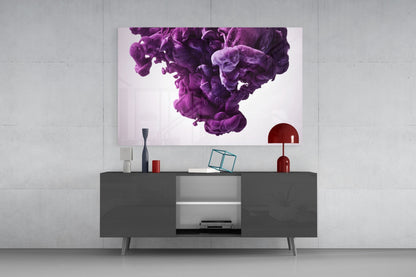 Purple smoke glass wall art displayed above a dark gray media console with red decorative objects and a table lamp in a modern interior setting.