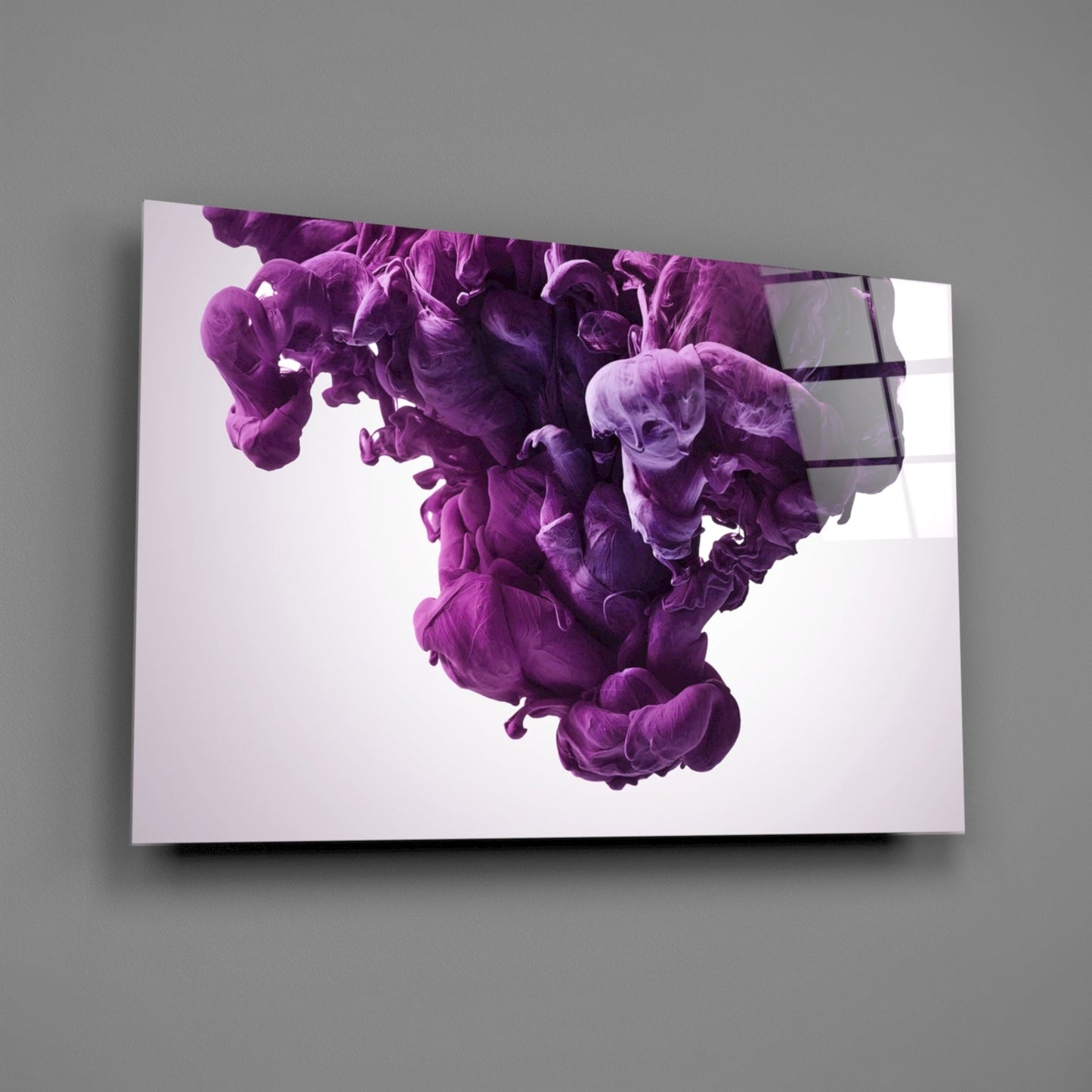 Mounted glass wall art displaying swirling purple and violet ink clouds against white background, viewed at angle on gray wall.