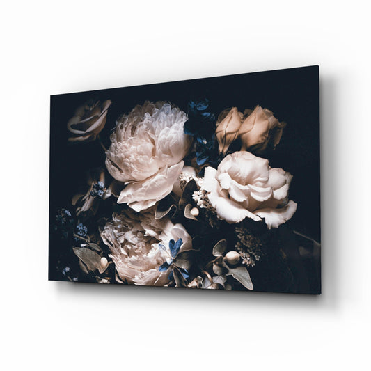 Glass wall art displayed at an angle showing cream and blush peonies with blue flowers on dark background.