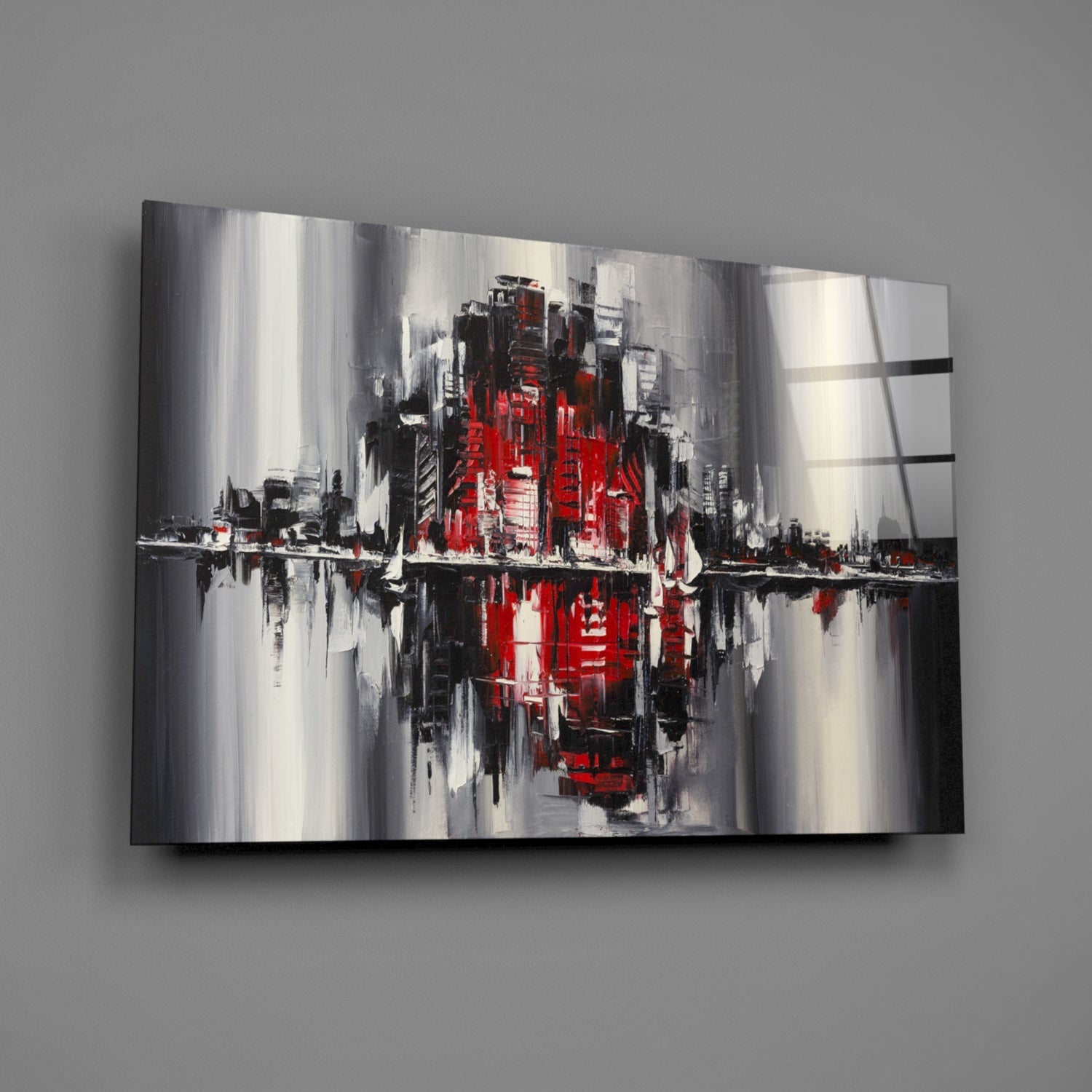 Abstract cityscape glass wall art featuring red, black, white and gray vertical brushstrokes with reflective surface, displayed at angle on gray wall.
