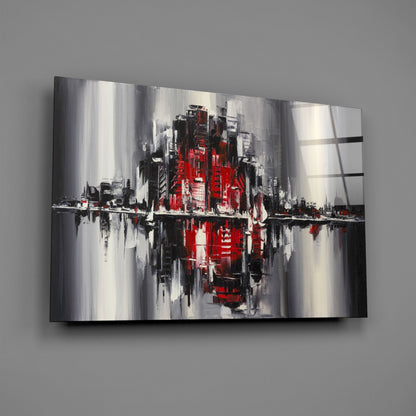 Abstract cityscape glass wall art featuring red, black, white and gray vertical brushstrokes with reflective surface, displayed at angle on gray wall.