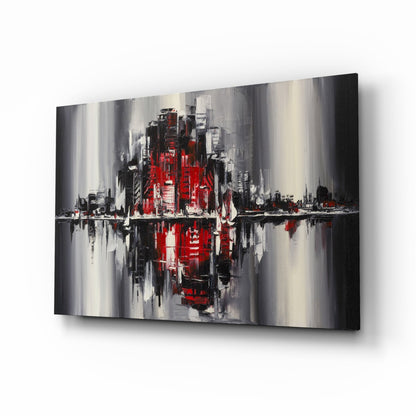 Abstract cityscape glass wall art featuring red and black buildings with gray streaks and mirrored water reflection effect, displayed at angle.