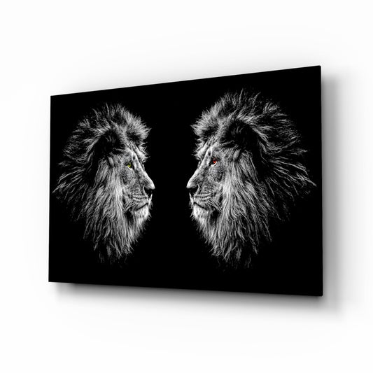 Two lion heads in profile facing each other on black glass with glowing green and amber eyes.