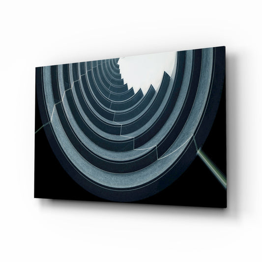 Angled perspective view of concentric curved concrete arcs in dark teal and gray tones against black background on mounted glass panel.