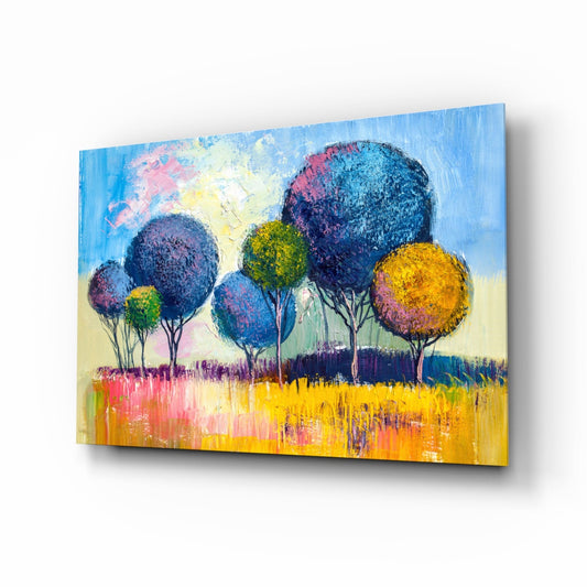 Colorful glass wall art depicting stylized trees with blue, yellow, and purple spherical foliage against a bright landscape, displayed at an angle.