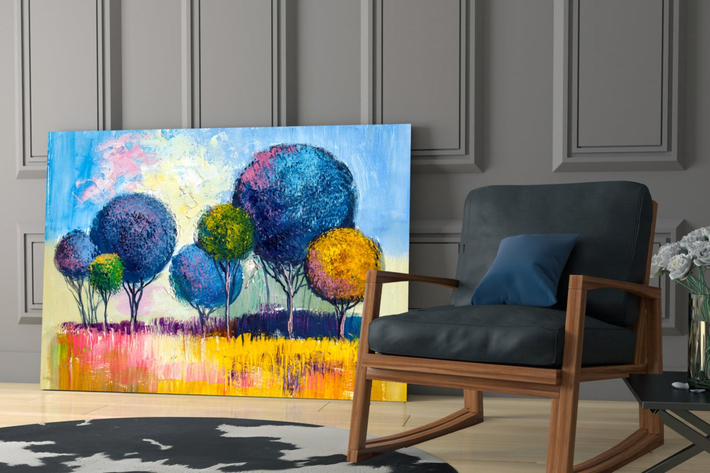 Colorful glass wall art featuring vibrant blue, yellow, and pink trees displayed in a modern living room next to a wooden rocking chair.