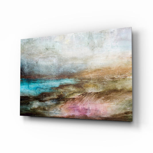 Glass wall art panel displayed at an angle showing layered landscape with turquoise water, brown earth tones, and pink accents.
