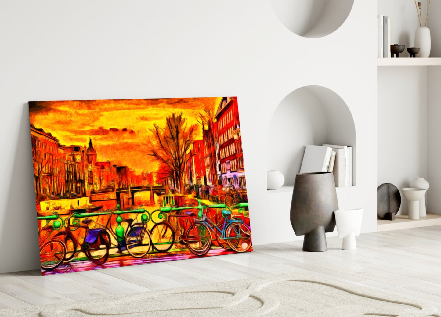 Vibrant glass wall art featuring colorful bicycles and orange sunset cityscape leaning against white wall in minimalist interior.