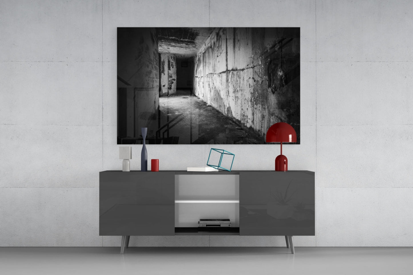 Black and white hallway glass wall art displayed above gray media console with red decorative accessories.