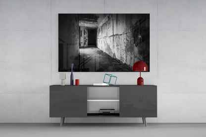 Black and white hallway glass wall art displayed above gray media console with red decorative accessories.