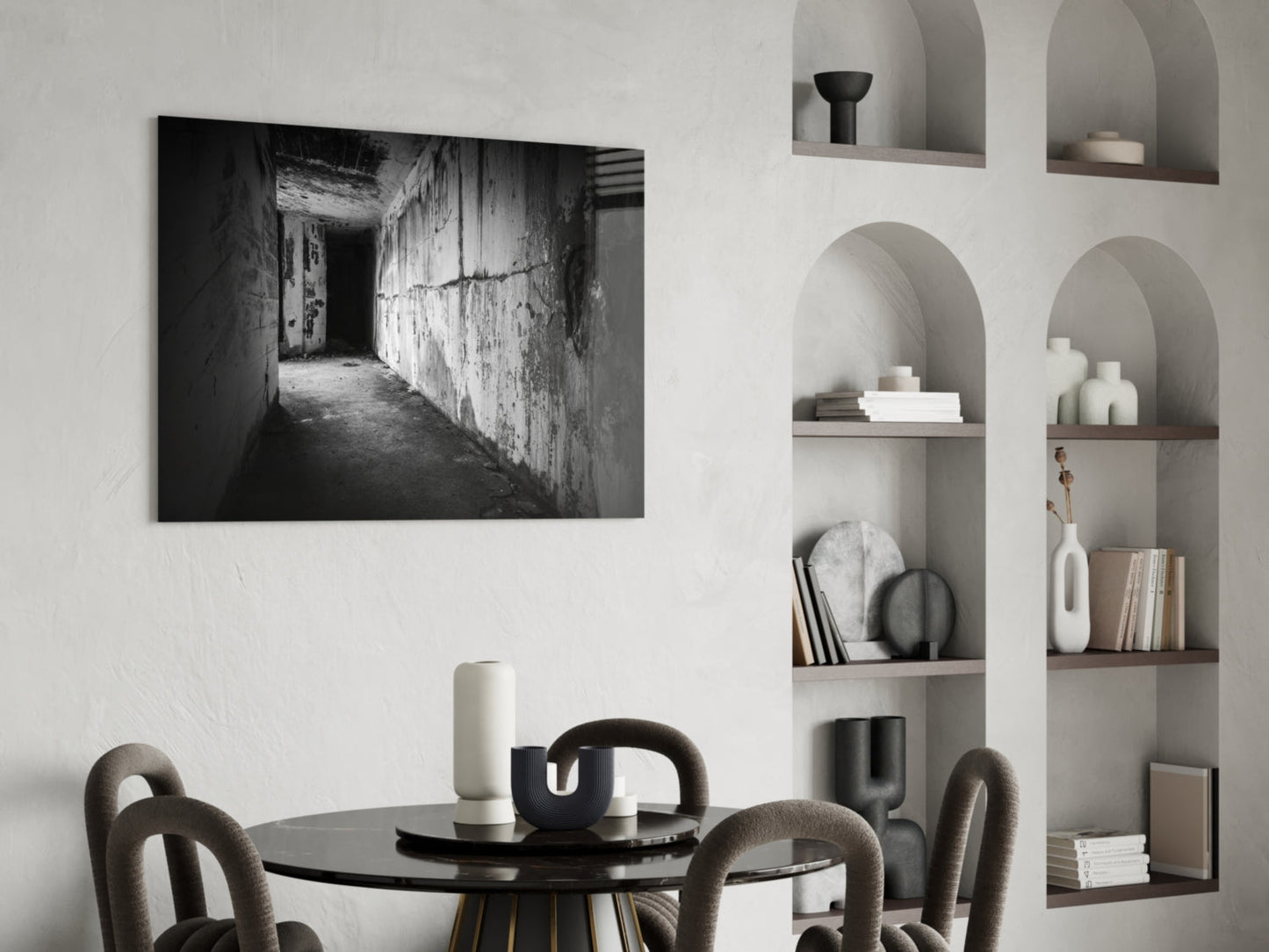 Black and white photograph of an abandoned concrete hallway with peeling walls displayed as glass wall art in a minimalist interior.
