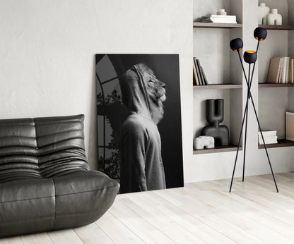 Black and white lion head glass wall art leaning against white wall in modern living room interior with gray sofa and shelving.