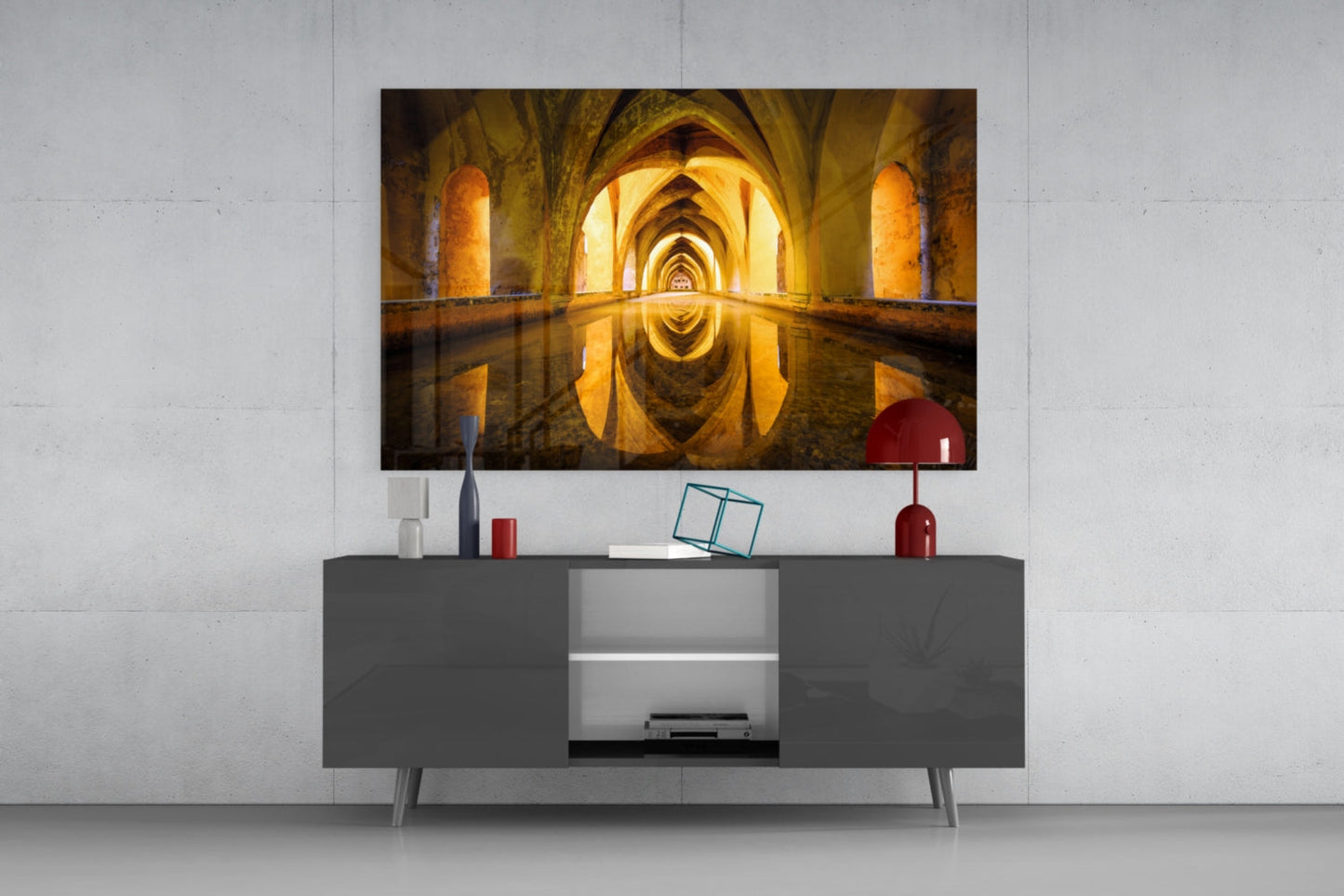 Cistern Glass Wall Art mounted above gray media console, displaying golden-lit arched corridor with water reflection.