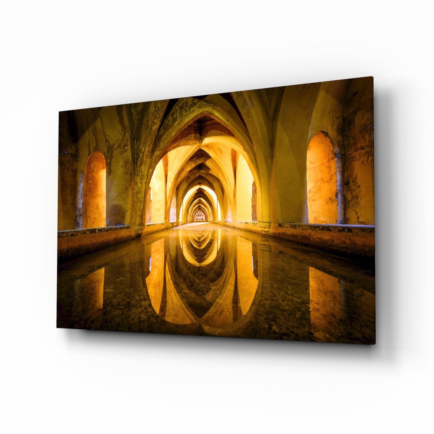 Illuminated vaulted archway with golden stone columns reflected in still water below, creating symmetrical vanishing point perspective.