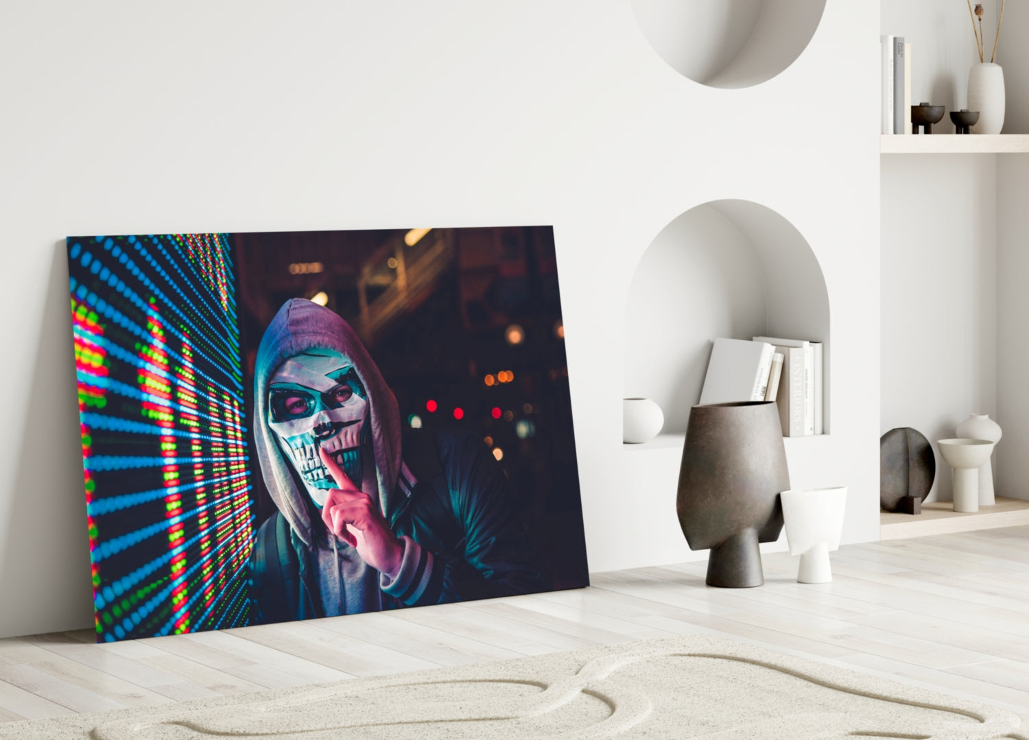 Vibrant neon skull artwork displayed as glass wall art in minimalist white interior setting with decorative objects.