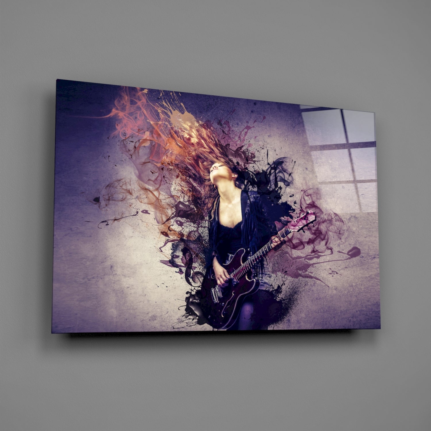 Glass wall art mounted on gray wall displaying female guitarist with flowing hair and colorful paint splash effects in purple and orange tones.