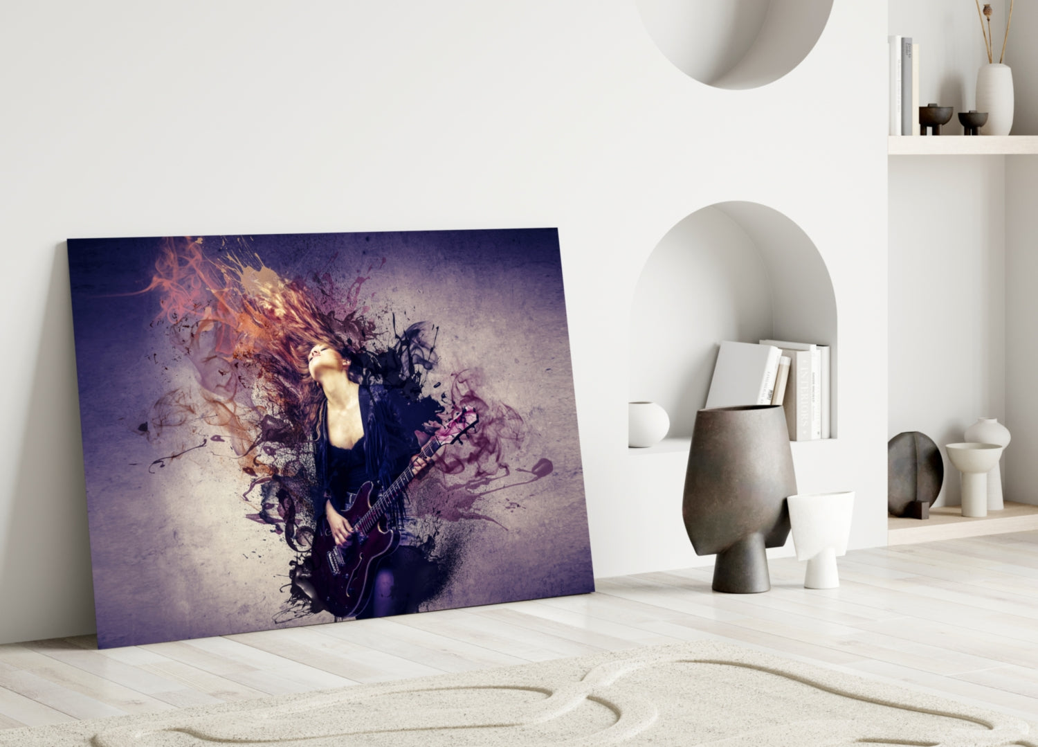 Rock glass wall art leaning against white wall displays musician with electric guitar dissolving into purple and orange abstract splatter effects.