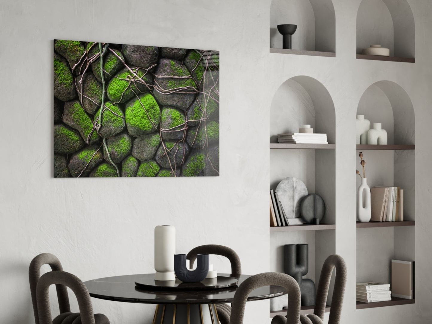Mossy Stones Glass Wall Art mounted above a black round dining table with gray upholstered chairs, showing green moss and gray stone texture with brown vine details.