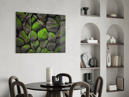 Mossy Stones Glass Wall Art mounted above a black round dining table with gray upholstered chairs, showing green moss and gray stone texture with brown vine details.