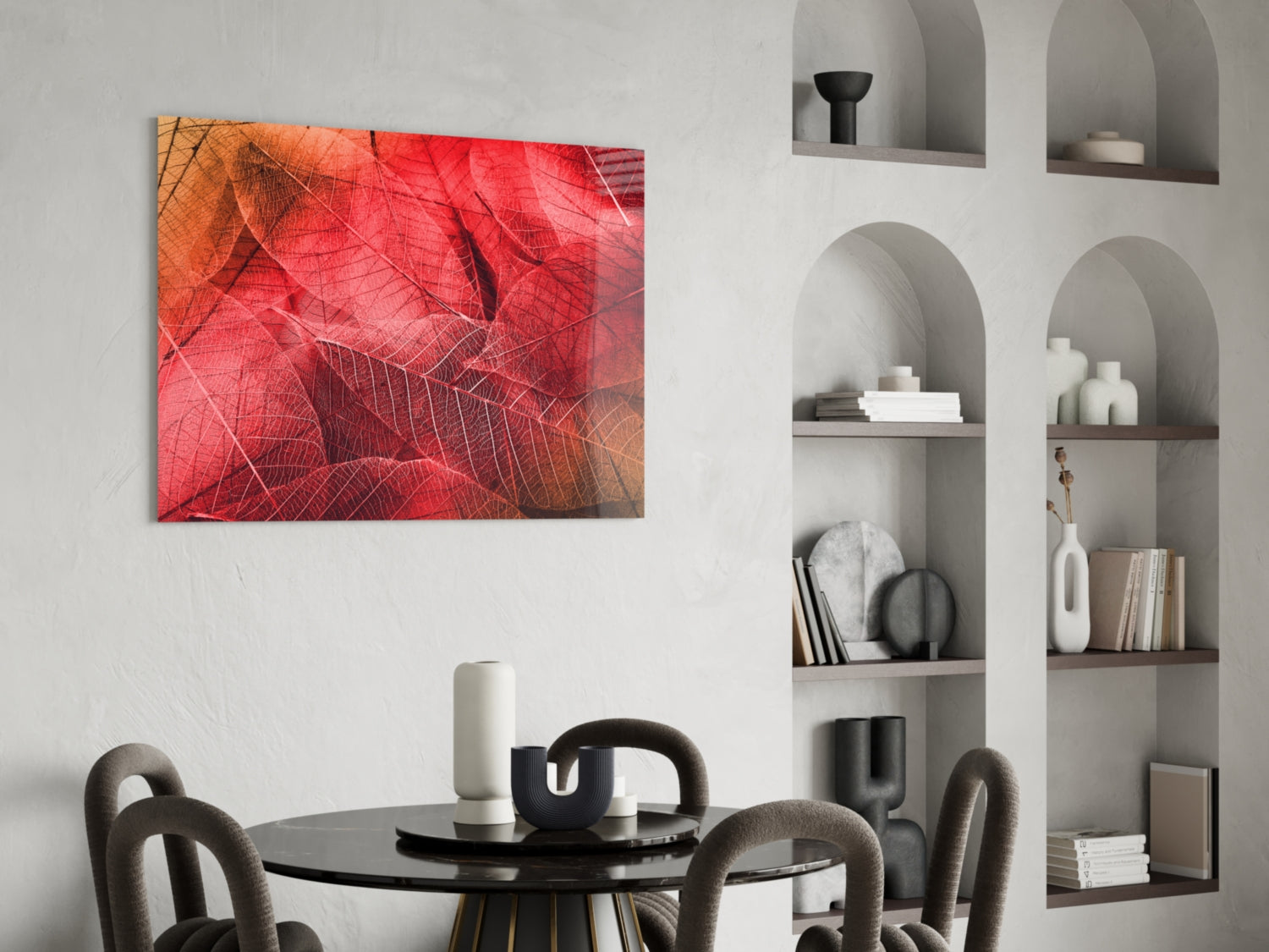 Red and orange macro leaf photograph displayed as glass wall art above a black round dining table with gray chairs.