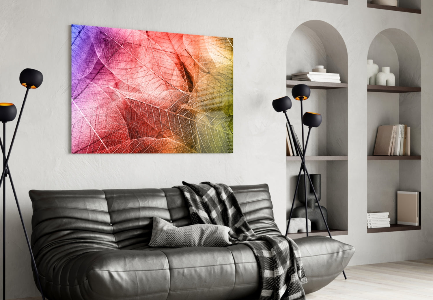 Colorful macro leaf glass art in pink, orange, and yellow tones displayed above black leather sofa in modern living room.