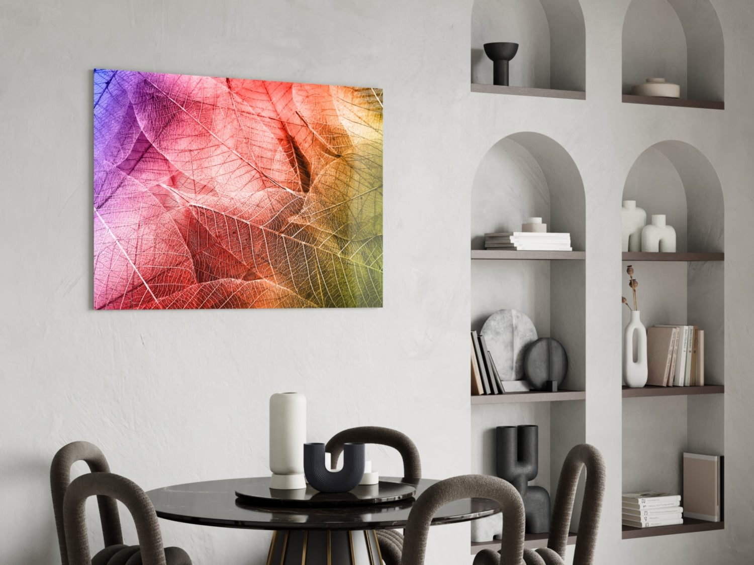 Colorful glass wall art with gradient leaf vein patterns in purple, pink, orange, and yellow hung above a black round dining table.