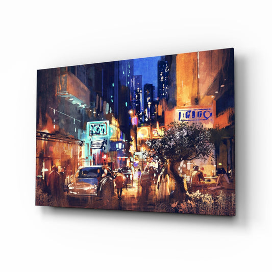 Glass wall art canvas angled to show a neon-lit urban street scene with warm orange and blue lighting, pedestrians, and illuminated storefronts.