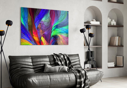 Vibrant abstract glass art with swirling blue, green, pink, and yellow patterns displayed above a black leather sofa in a modern living room.